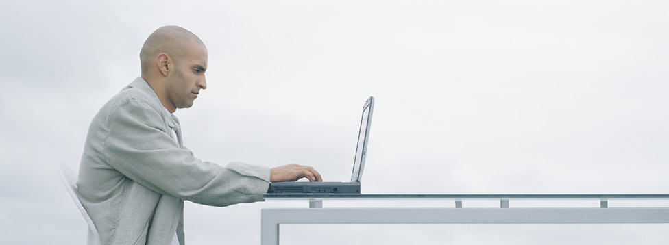 Zeigt einen Detektiv bei Ermittlungen mit Laptop, Outdoor-Umgebung, professionell und fokussiert.